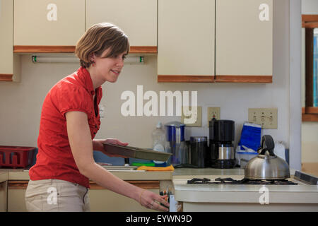 Young blind woman cooking in her kitchen Stock Photo