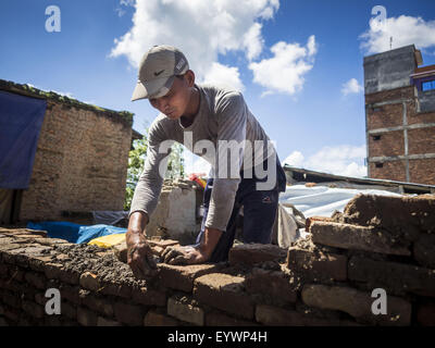 Sankhu, Central Region, Nepal. 3rd Aug, 2015. A man rebuilds a home destroyed by the earthquake in Sankhu, a community about 90 minutes from central Kathmandu. He is using bricks recycled from the original home and mud from the earthquake rubble as mortar. The Nepal Earthquake on April 25, 2015, (also known as the Gorkha earthquake) killed more than 9,000 people and injured more than 23,000. It had a magnitude of 7.8. © ZUMA Press, Inc./Alamy Live News Stock Photo