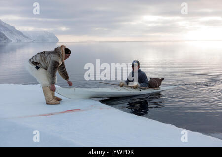 Inuit hunters use a kayak with a sealskin float to retrieve seals hunted at the floe edge, Greenland, Denmark, Polar Regions Stock Photo