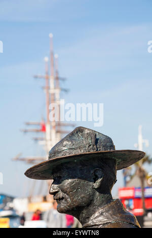 Statue of Lord Robert Baden Powell, founder of the Scouting movement, at Poole Quay with tall ship Kaskelot in the distance Stock Photo