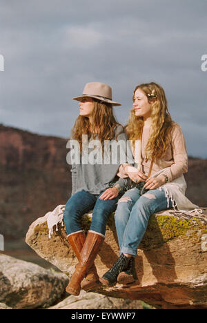 Two women wearing leather boots on rock in desert Stock Photo