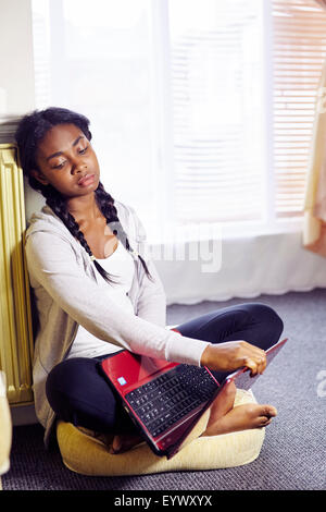 Frustrated ethnic girl sat indoors Stock Photo