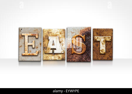 The word 'EAST' written in rusty metal letterpress type isolated on a white background. Stock Photo