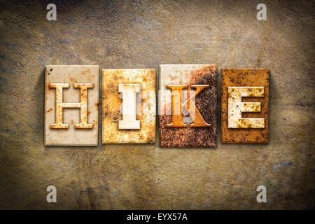 The word "HIKE" written in rusty metal letterpress type sitting on a