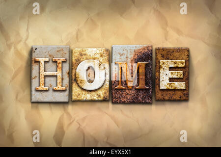 The word 'HOME' written in rusty metal letterpress type on a crumbled aged paper background. Stock Photo