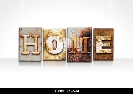 The word 'HOME ' written in rusty metal letterpress type isolated on a white background. Stock Photo