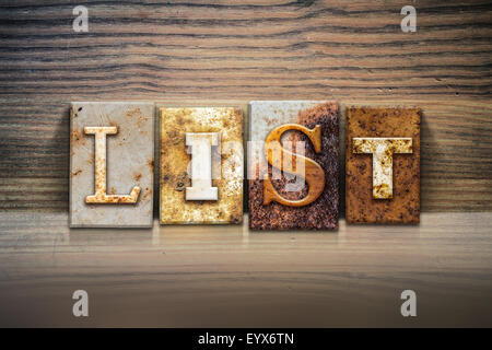 The word 'LIST' written in rusty metal letterpress type sitting on a wooden ledge background. Stock Photo