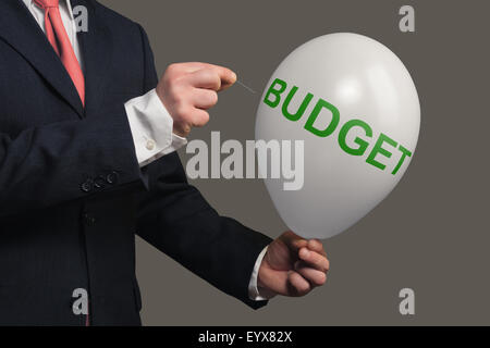 Man in Suit lets a Dream burst with a needle Stock Photo