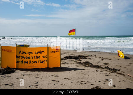 Surf lifesaving, warning flags and equipment on beach ready for use by RNLI lifeguards Stock Photo