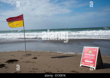 Surf lifesaving, warning flags and equipment on beach ready for use by RNLI lifeguards Stock Photo