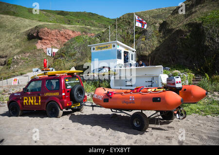 Surf lifesaving, warning flags and equipment on beach ready for use by RNLI lifeguards Stock Photo