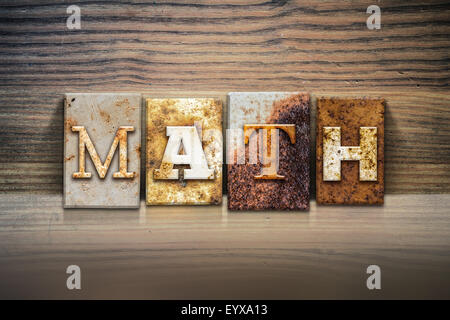 The word 'MATH' written in rusty metal letterpress type sitting on a wooden ledge background. Stock Photo