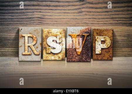 The word "RSVP" written in rusty metal letterpress type sitting on a wooden ledge background. Stock Photo