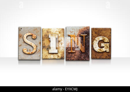 The word 'SING' written in rusty metal letterpress type isolated on a white background. Stock Photo