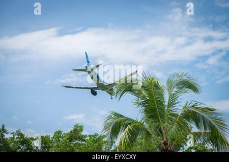 Commercial airplane approaching tropic destination airport Stock Photo