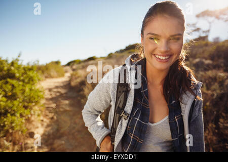 Outdoor shot of happy young woman hiking on a sunny day. Caucasian