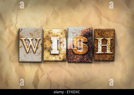 The word 'WISH' written in rusty metal letterpress type on a crumbled aged paper background. Stock Photo