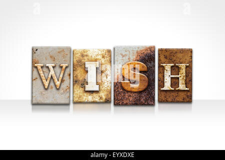 The word 'WISH' written in rusty metal letterpress type isolated on a white background. Stock Photo