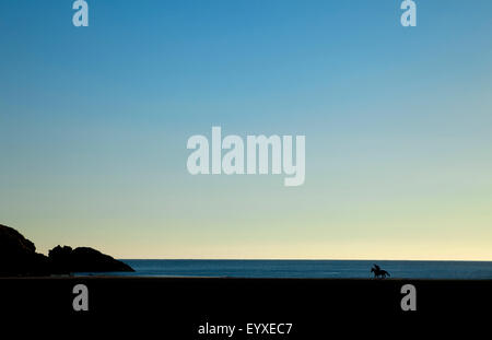 Horse and Rider on Stradbally Beach in the Copper Coast Geopark, County Waterford, Ireland Stock Photo