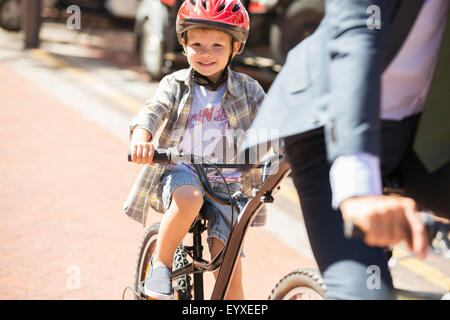 Portrait smiling boy riding bicycle on sunny road Stock Photo
