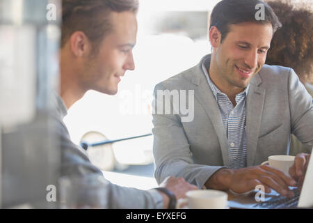 Businessmen with coffee working at laptop in cafe Stock Photo