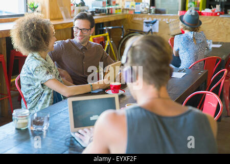 Friends sharing digital tablet in cafe Stock Photo