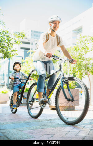 Mother and son riding bicycles on urban path Stock Photo
