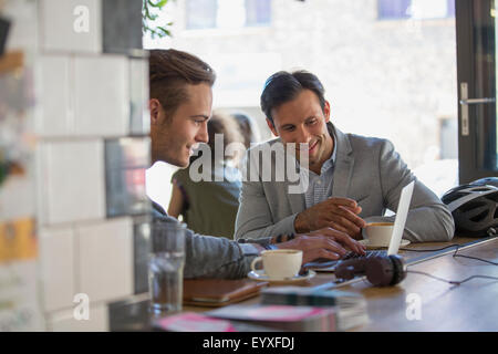 Businessmen with coffee working at laptop in cafe Stock Photo