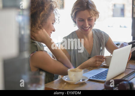 Businesswomen with coffee working at laptop in cafe Stock Photo