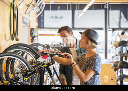 Couple looking at price tags on bicycles in bicycle shop Stock Photo