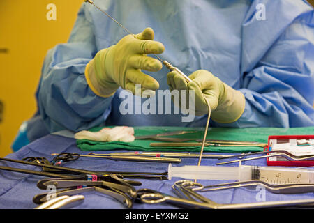 Englewood, Colorado - A nurse prepares tools during lumbar spine surgery at Swedish Medical Center. Stock Photo