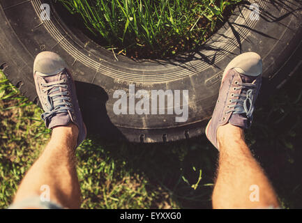 Man standing on old tire, tinted photo Stock Photo
