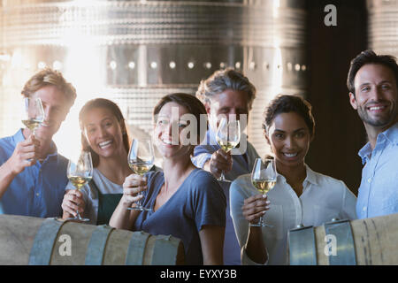 Portrait smiling friends wine tasting in winery cellar Stock Photo