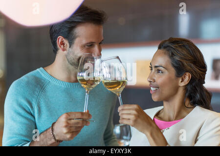 Smiling couple toasting white wine glasses Stock Photo