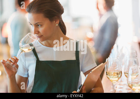 Winery employee smelling white wine in tasting room Stock Photo