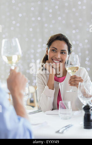 Couple drinking white wine at restaurant table Stock Photo