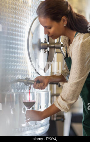 Vintner barrel tasting red wine in stainless steel vat Stock Photo