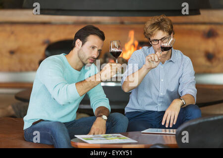 Men wine tasting red wine in winery tasting room Stock Photo