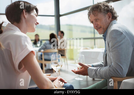 Couple drinking wine and talking in restaurant Stock Photo