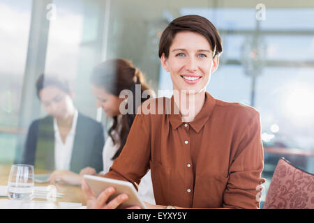 Portrait smiling businesswoman with digital tablet in office Stock Photo