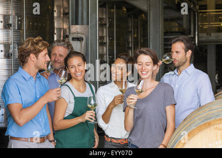 Winery employees tasting white wine in cellar Stock Photo