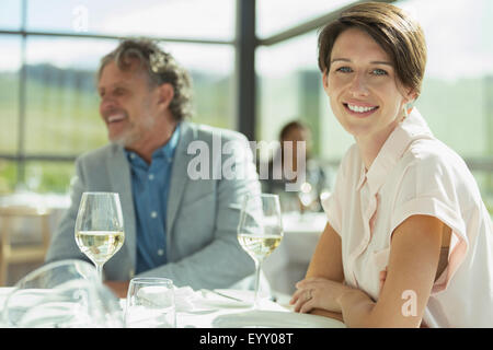 Portrait smiling woman drinking wine in sunny restaurant Stock Photo