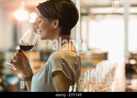 Woman wine tasting red wine in winery tasting room Stock Photo