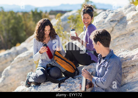 Hikers resting on rocky hillside Stock Photo