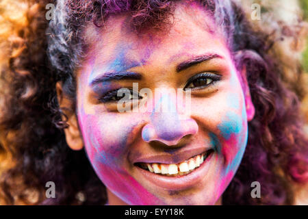 Smiling mixed race woman covered in pigment powder Stock Photo