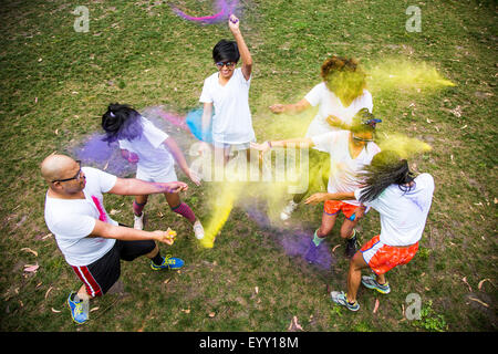 Friends throwing pigment powder in playful fight Stock Photo