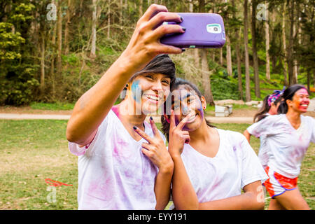 Friends taking selfie covered in pigment powder Stock Photo
