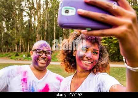 Couple taking selfie covered in pigment powder Stock Photo