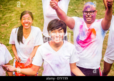 Smiling friends covered in pigment powder cheering Stock Photo