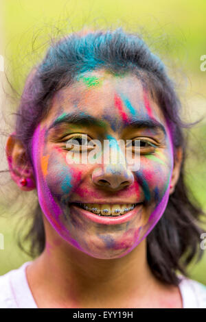 Smiling Hispanic girl covered in pigment powder Stock Photo